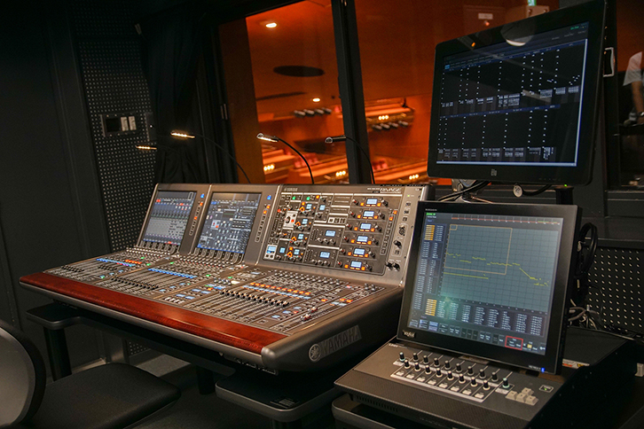 大ホール音響室　音響調整卓はヤマハ「RIVAGE PM10」を導入
 右手手前はマトリクスコントローラーHYFAX「LDM1」、右手上の液晶画面はデータロガー「DL3 System」用ディスプレイ 