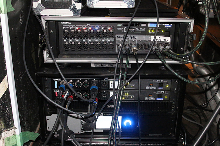 I/Oラック「ヤマハRio1608-D」とL2スイッチ「ヤマハSWP1-8MMF」、最下段に「NEXO NXAMP4×2MK」パワーアンプが収納されたラック。舞台上手に設置